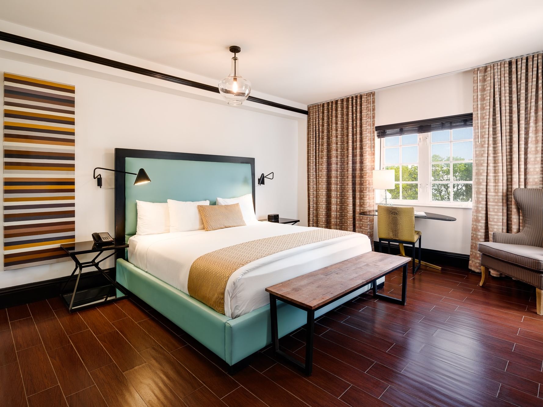 Classic King Room at The Croydon Hotel Miami Beach with bedside tables, a bench, a chair, and a window with curtains.