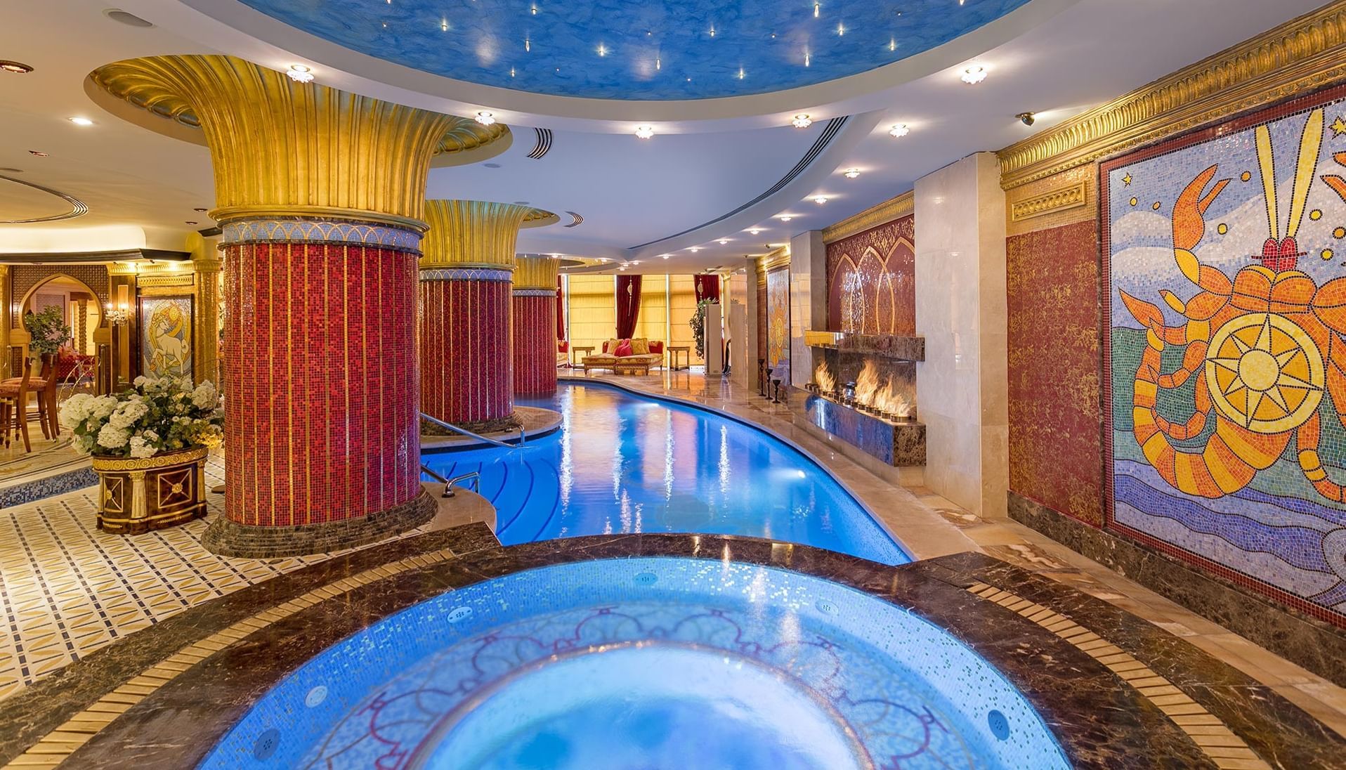 Luxury lobby area with lit pools and mosaic walls at Titanic Mardan Palace 