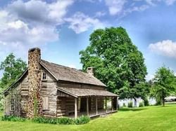 a wooden cottage and lush green trees