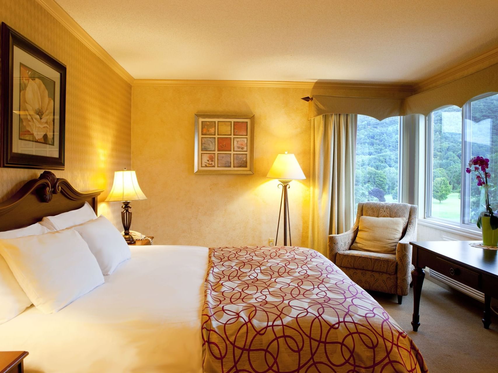 Bed, table and sofa chair in Standard Room at Honor’s Haven