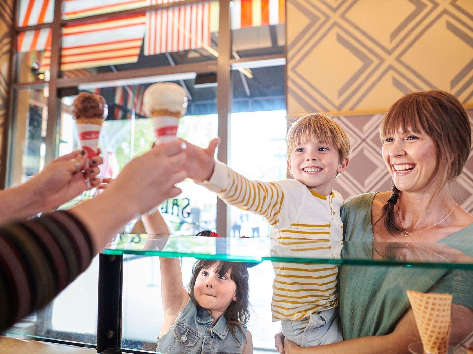 Family choosing ice cream flavors at a counter in Fuel Up For The Magic offer.