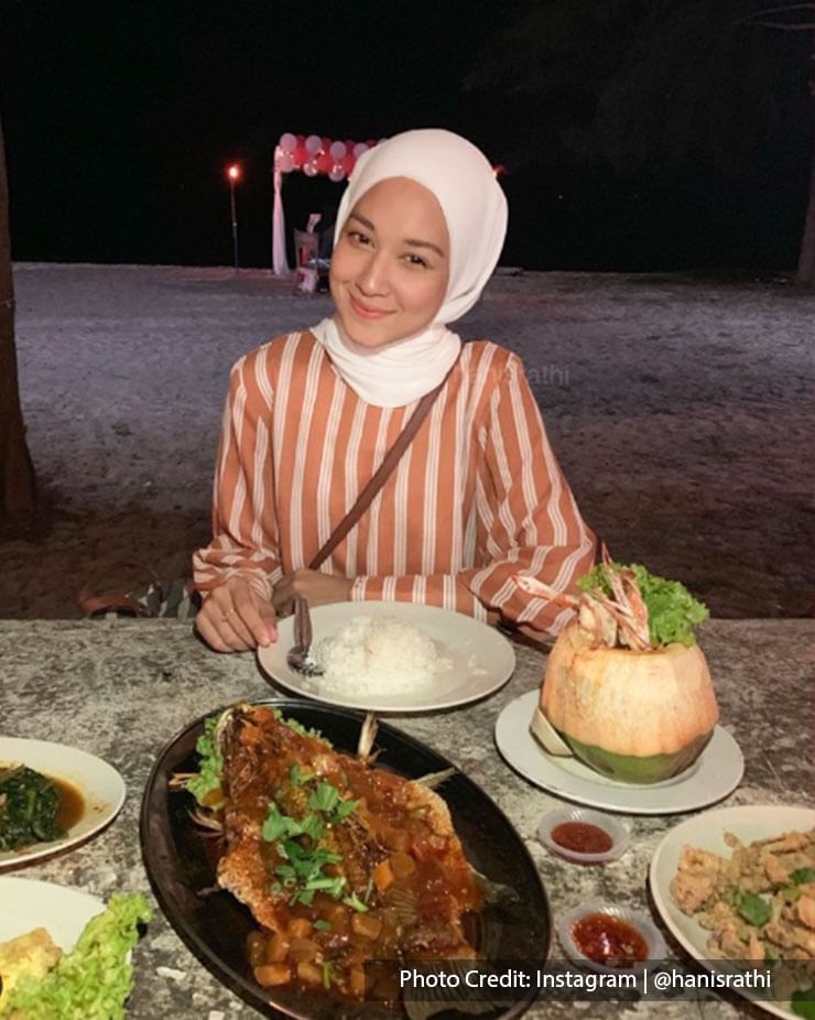 Woman posing in front of dishes at at Embok Village Steamboat and Seafood, Port Dickson