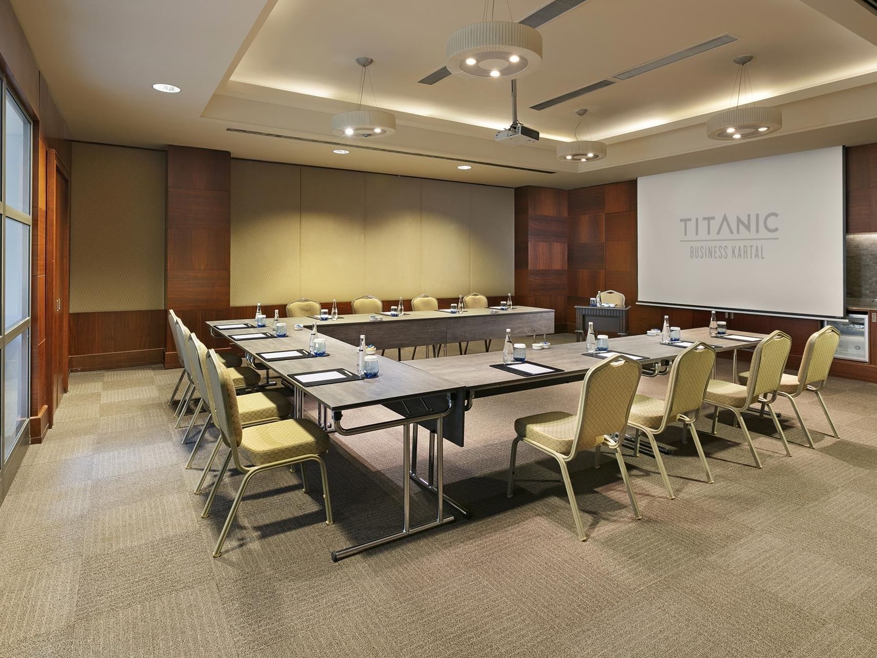   Titanic Business Kartal’daki Majorca toplantı salonunda, U düzeninde sandalye masalar ve projeksiyon ile hazırlanmış toplantı odası.