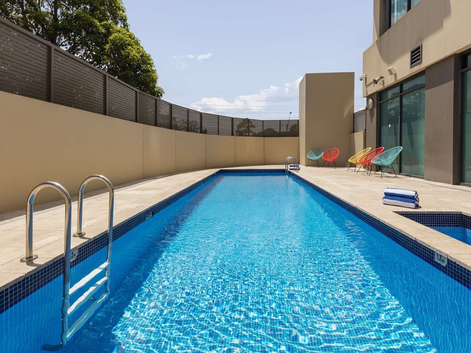 Outdoor heated swimming pool area at Nesuto Parramatta Apartment Hotel