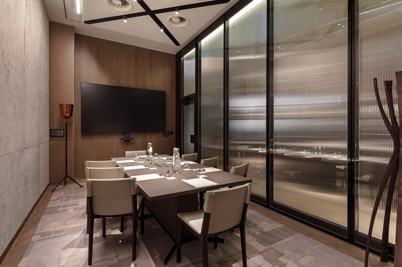 Somerset House meeting room at The Londoner Hotel, set with a large table, modern chairs, and a wall-mounted TV