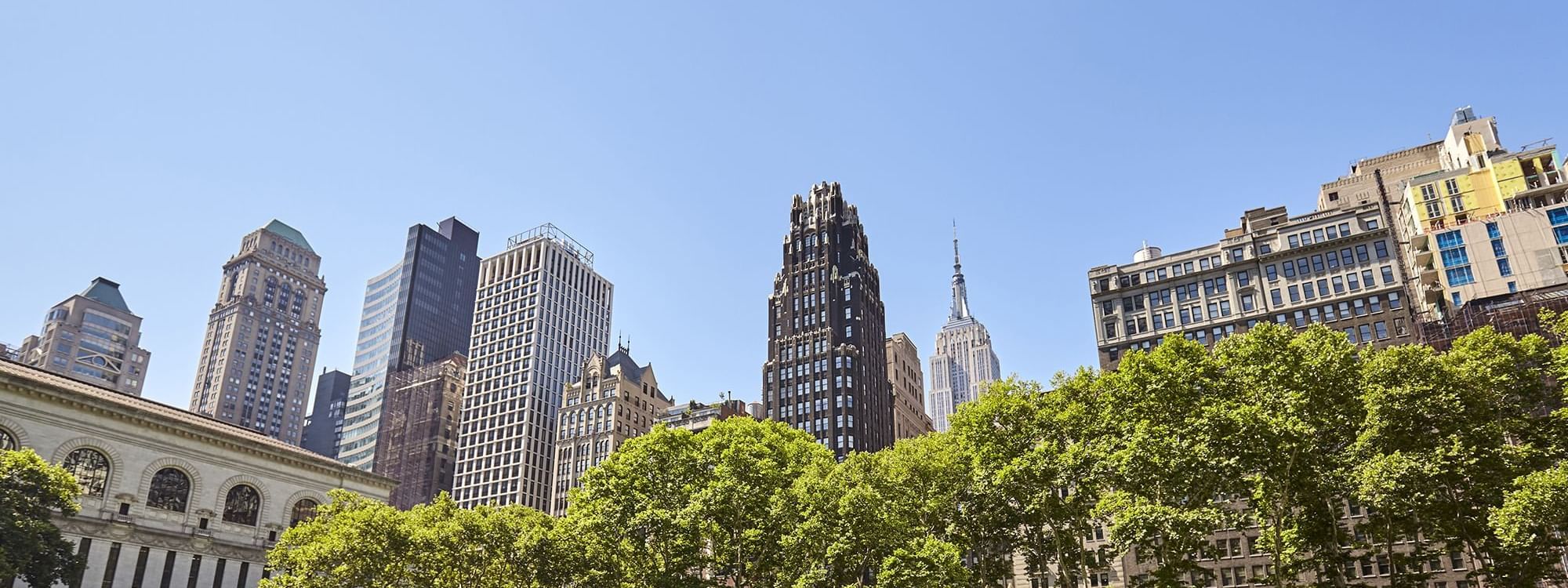 Bryant Park surrounded by skyscrapers near Warwick Hotels & Resorts