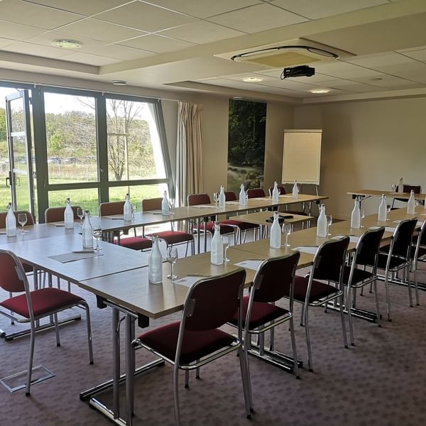 U-shaped long tabled meeting room setup at The Originals Hotels