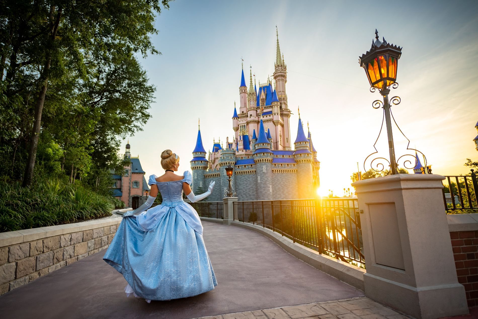 Cinderella character posing in front of castle at sunset near Lake Buena Vista Resort Village & Spa