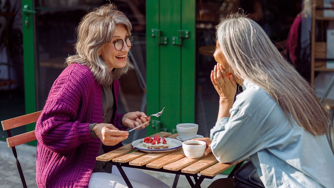two women sitting outside at a cafe