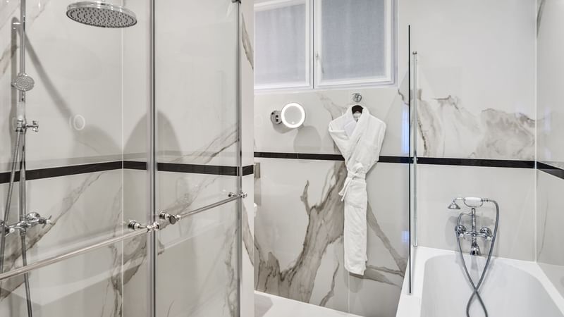 Modern bathroom featuring a glass shower and elegant marble walls in Executive Room at Hôtel Westminster - Paris
