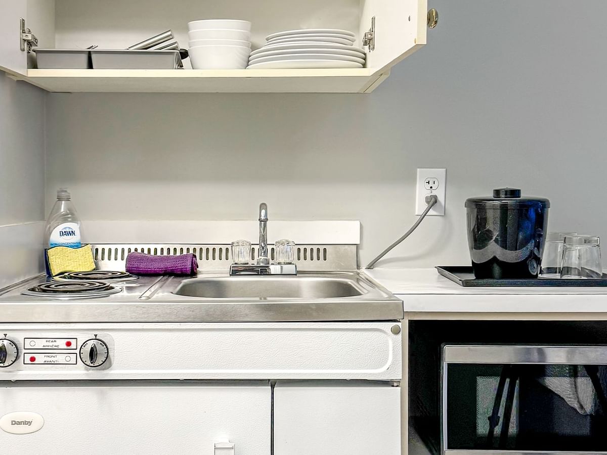 Kitchenette with sink, microwave, dishes and soap