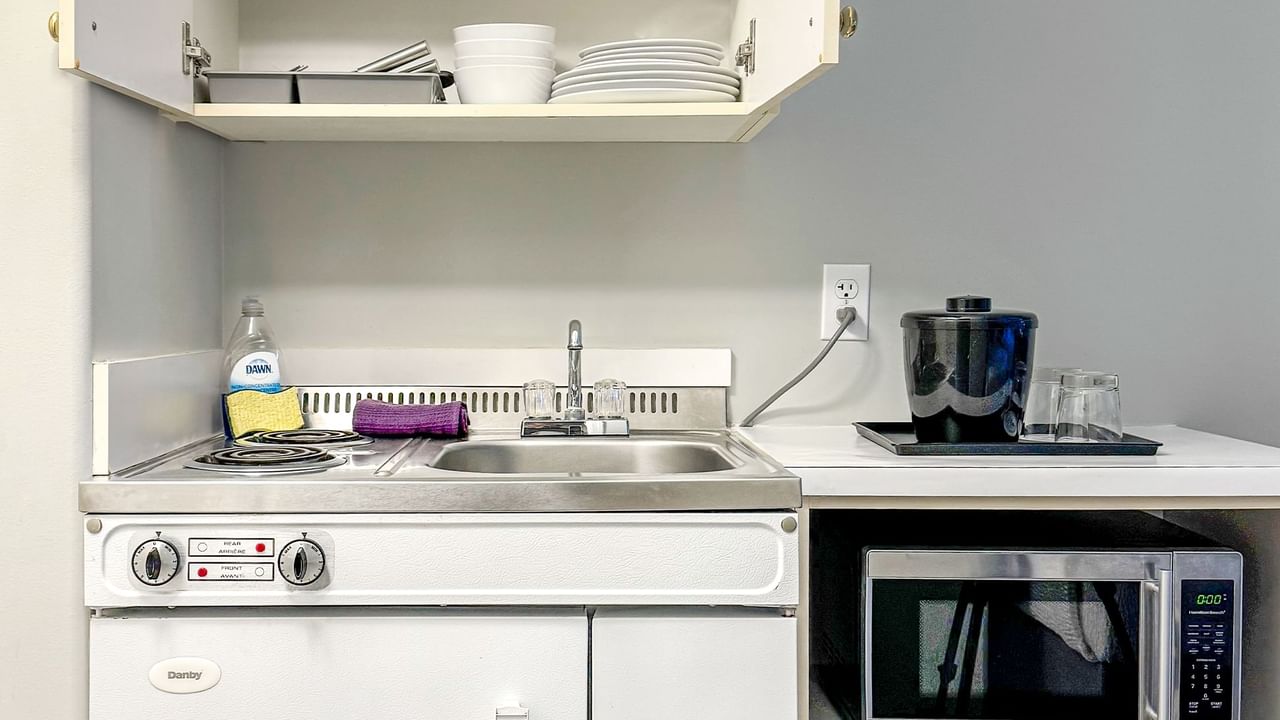 Kitchenette with sink, microwave, dishes and soap