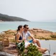 Couple sitting on a rock near the Bay at Freycinet Lodge