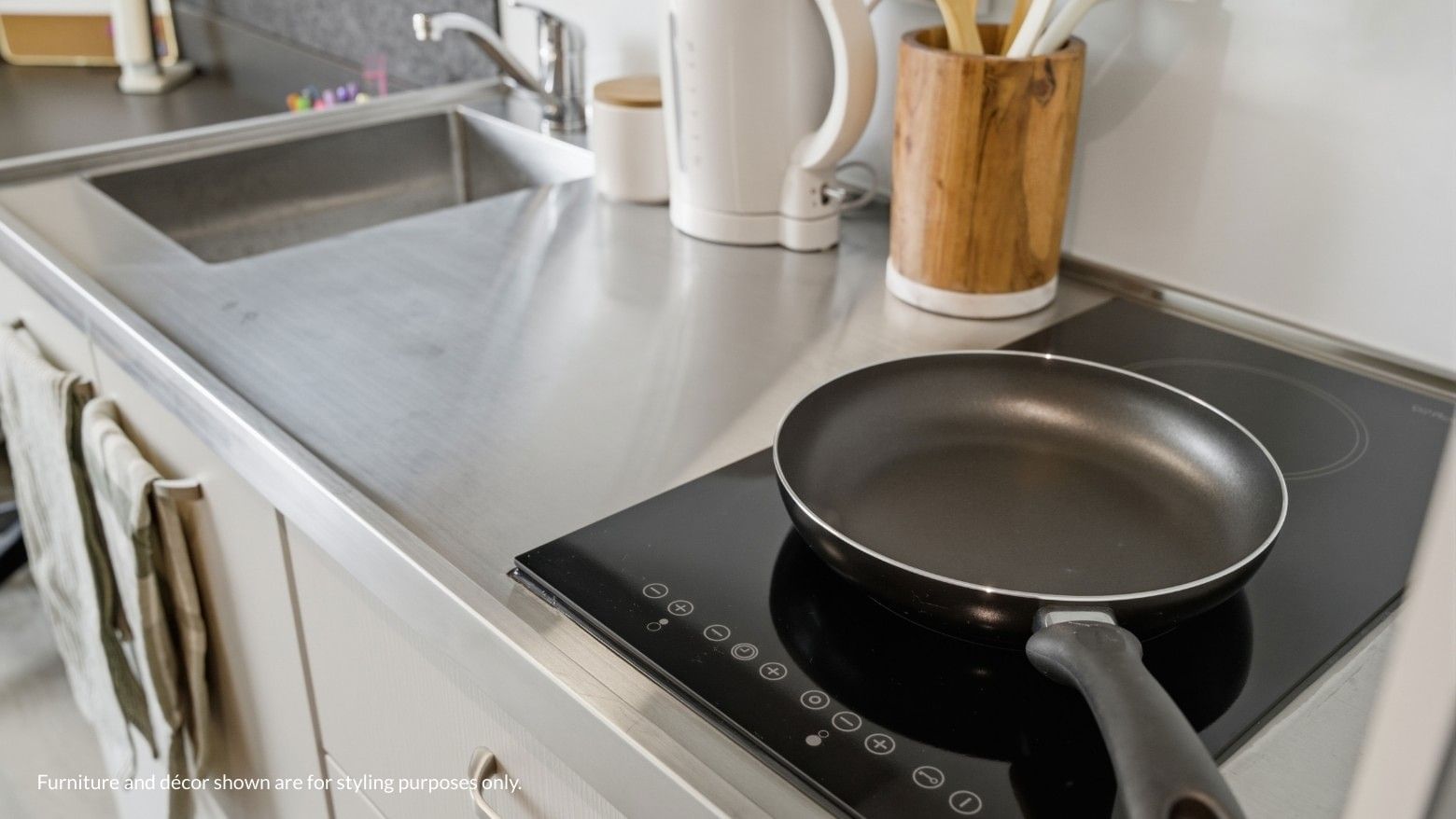 Frying pan on an induction stove with kitchen utensils nearby at Mayoral Drive Student Accommodation.