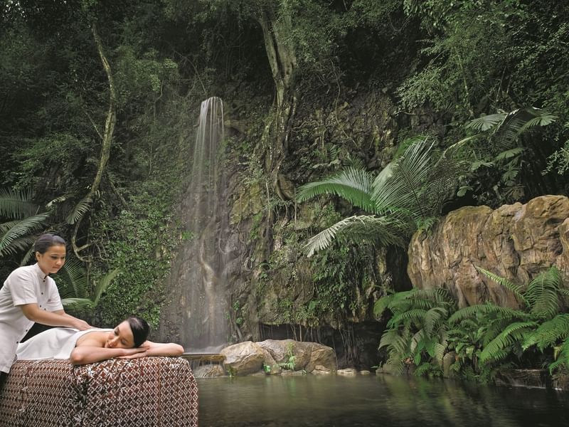 Lady receiving a massage by a mini waterfall in the Wellness Spa at The Banjaran Hotsprings Retreat