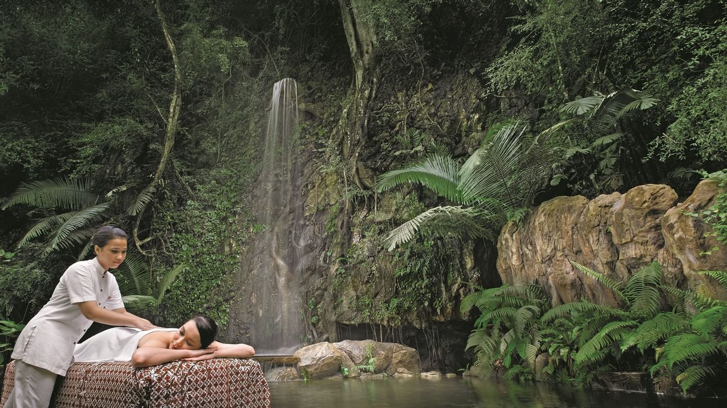 Lady receiving a massage by a mini waterfall in the Wellness Spa at The Banjaran Hotsprings Retreat