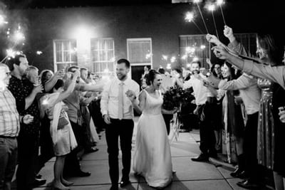 Bride and groom walk through crowd near Hotel at Old Town Wichita