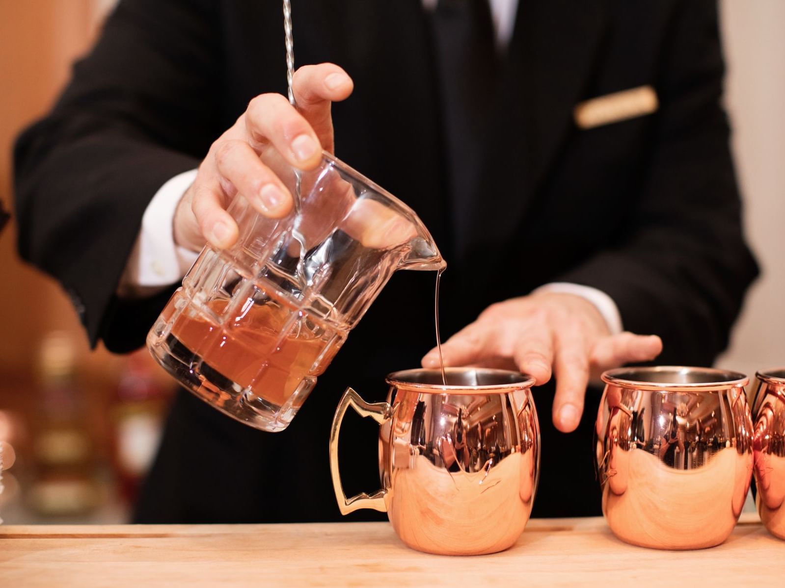 Close-up of bartender pouring a cocktail on The Bar & Lounge counter at The Umstead Hotel and Spa