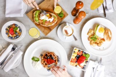 table with assorted breakfast plates and mimosas
