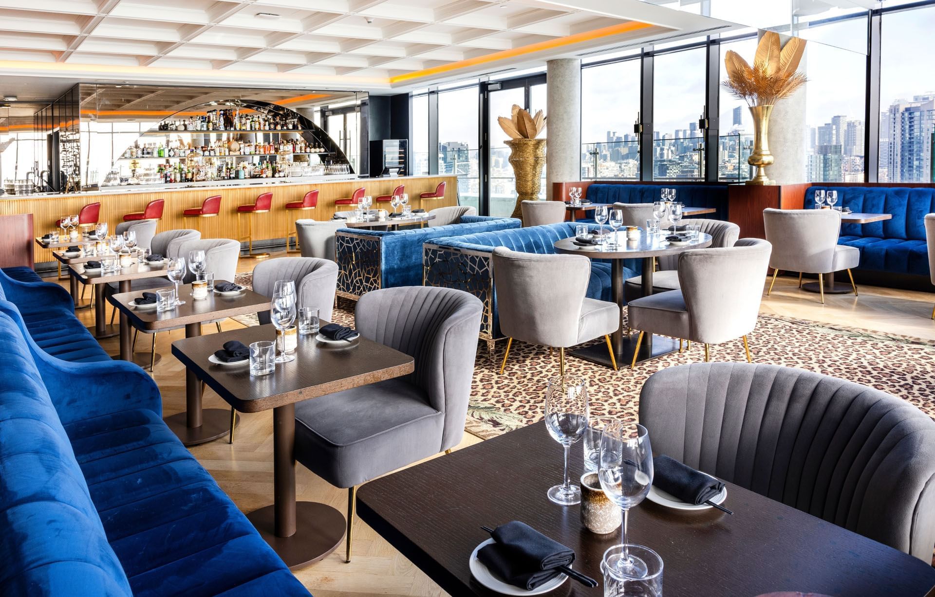Restaurant Valérie avec des sièges confortables, un bar moderne, des tables dressées et une vue sur les toits de la ville. à l'hôtel X Toronto
