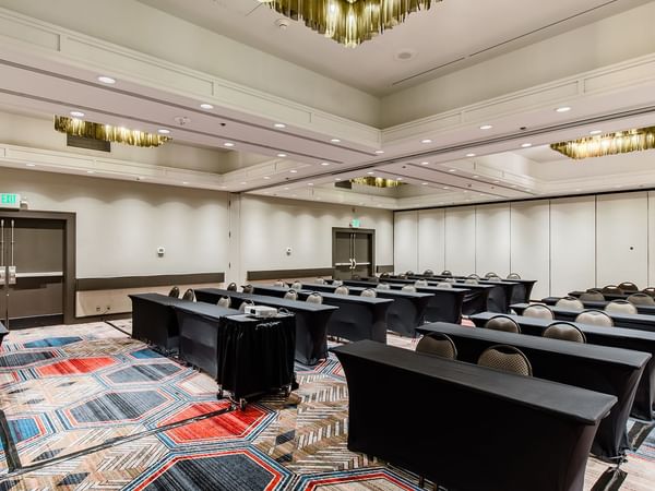 Meeting venue with tables, chairs, and a projector screen