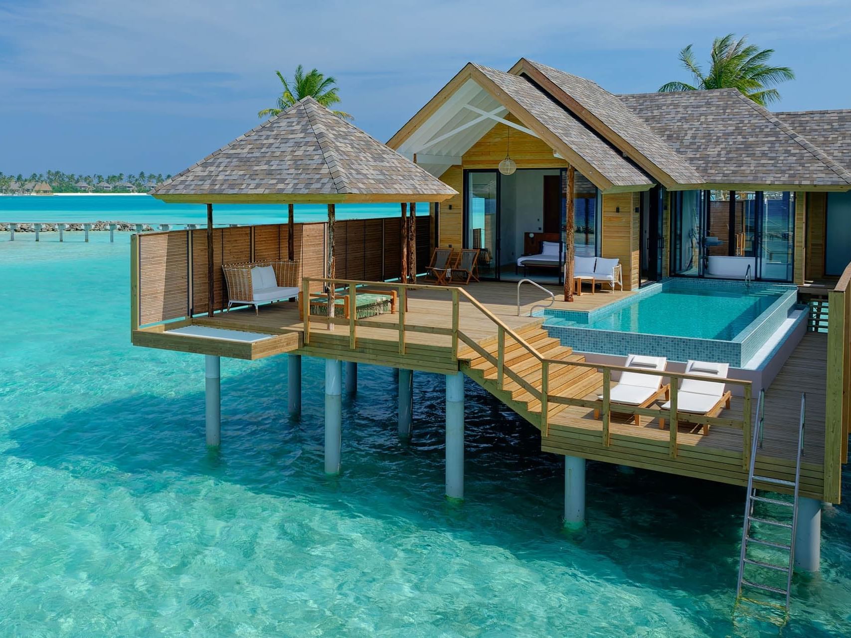 Exterior view of Deluxe Water Pool Villa with wooden deck, surrounded by turquoise waters at Ananea Madivaru Maldives