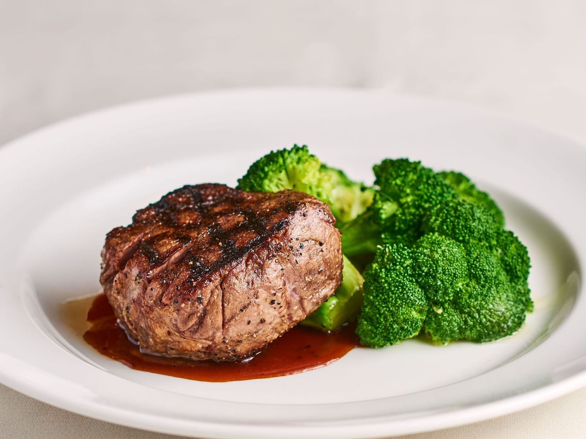 steak on white plate with brocolli