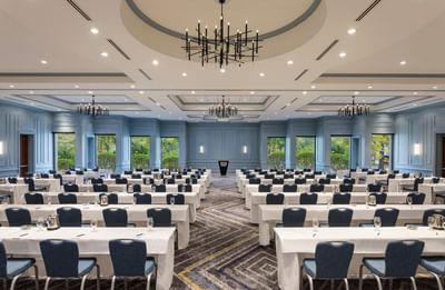 Classroom setup with rows of white-clothed tables and chairs in the Grand Ballroom at Sable Oaks Weddings and Events