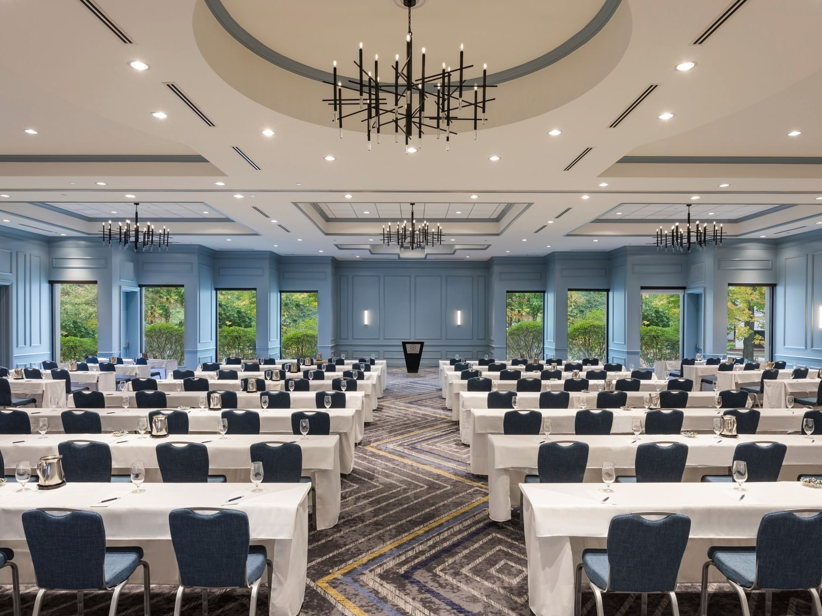 Classroom setup with rows of white-clothed tables and chairs in the Grand Ballroom at Sable Oaks Weddings and Events