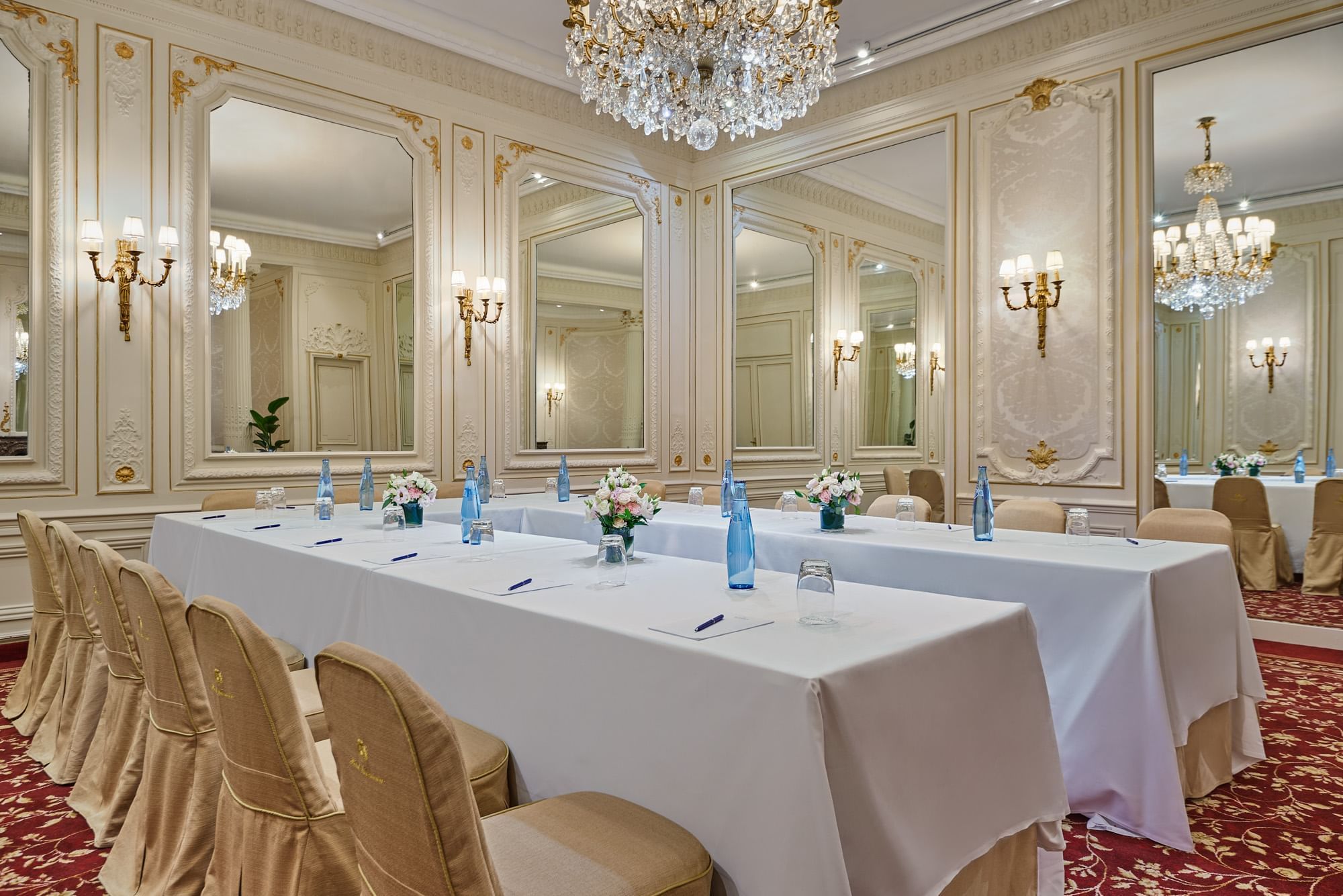 U-shaped table with lavish chandelier and mirrored walls in Capucines at Hôtel Westminster - Paris