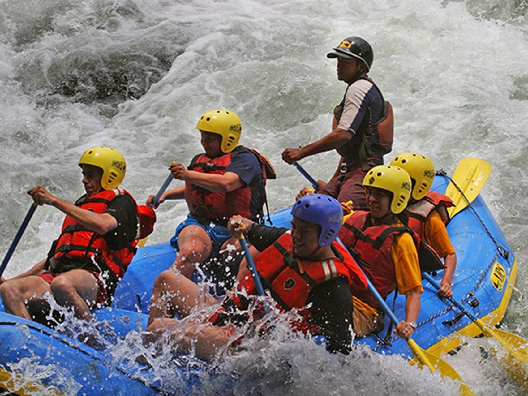 Group of people white water rafting on a river near El Silencio Lodge and Spa