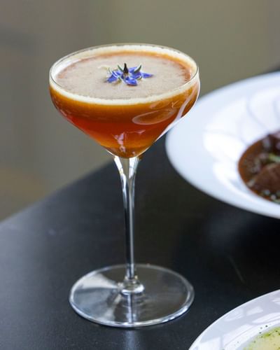 Cocktail garnished with a borage flower served in the restaurant at The Ashbrook Hotel