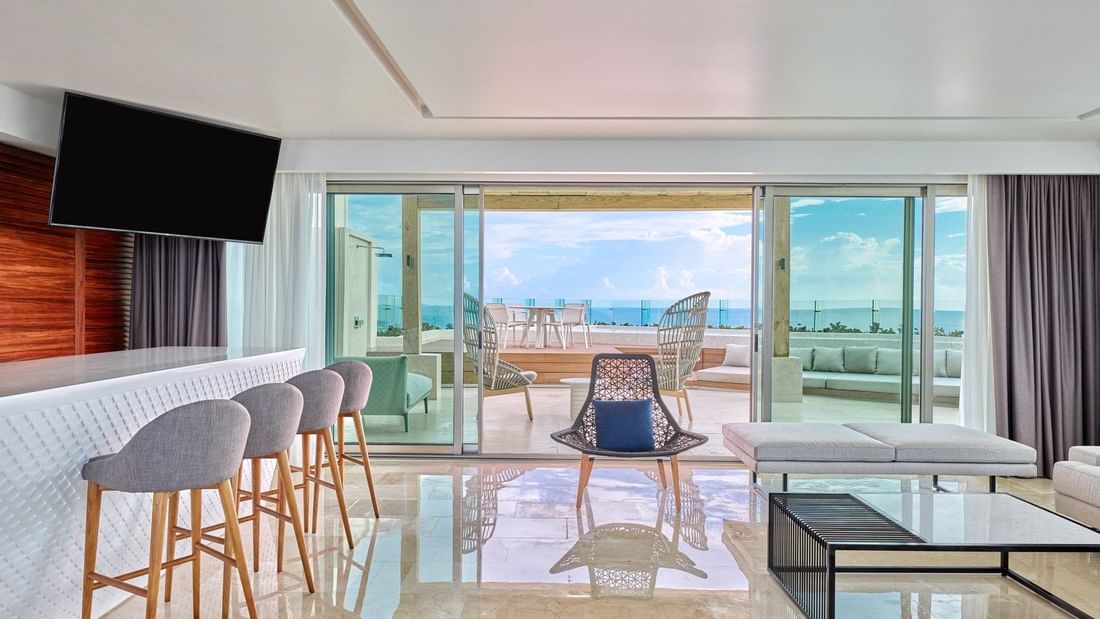 Spacious Presidential Sol y Luna Suite living room with TV and balcony area at Live Aqua Cancun