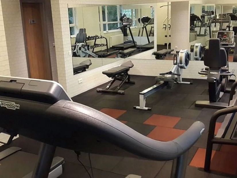 Rowing machine and weight bench on a rubber floor by large mirrors in the gym at Warwick Ankara