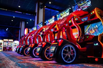 Rows of red motorcycle racing arcade games in Paradise Pier with glowing blue wheels at Margaritaville Resort Biloxi