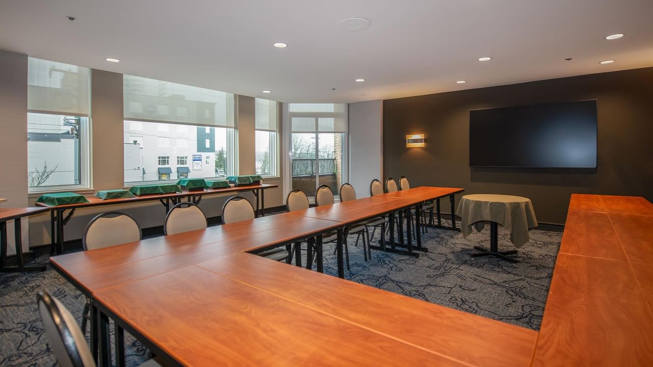 Meeting room with large tables and chairs at Coast Bastion Hotel.