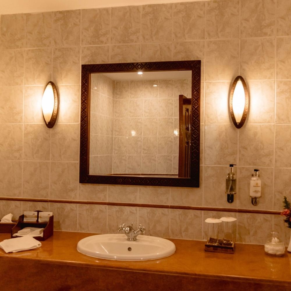Elegant bathroom with tiled walls, mirror, and sink at Arusha Serena Hotel, Arusha.