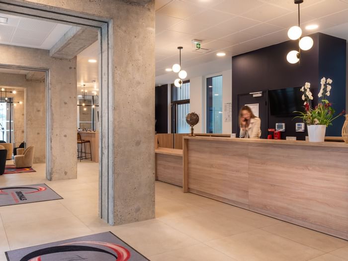 A receptionist at the reception desk in Residence Le Monde
