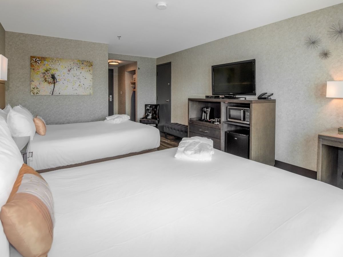 Coast Premium Two Queens with two queen beds, desk with chair, TV, and artwork at Coast Lonsdale Quay Hotel