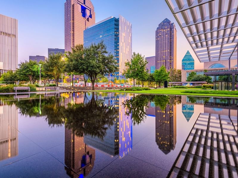City skyline with modern skyscrapers reflected in a calm pond at Warwick Corporate