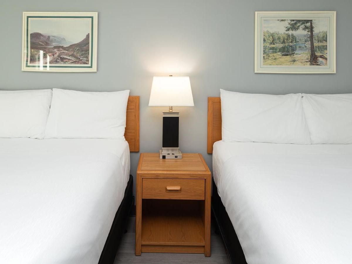 Coast Two Queens Pet Friendly room with two queen beds, wooden nightstand, and landscape artwork.