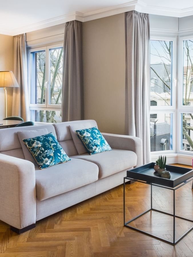 Dining table by the living area with plush seating and outdoor views in the Premium Suite at Warwick Reine Astrid - Lyon
