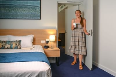 Lady entering a Suite bedroom area at Nesuto Curtin Perth Hotel