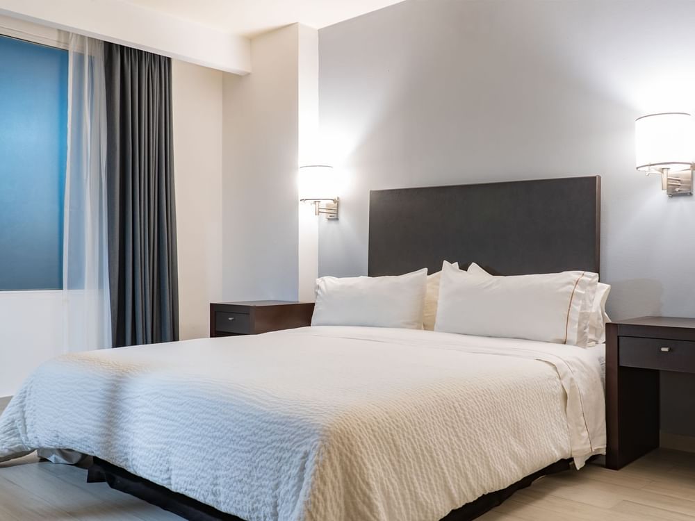 Accessible Room with double bed, wall lamps and window at Fiesta Inn