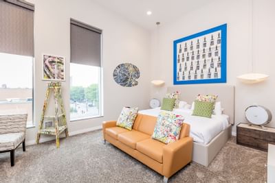 Large bed, sofa & wall decor in King Premiere Studio at Retro Suites Hotel