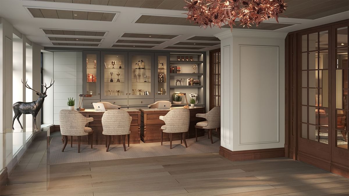 Lobby with a desk, chairs, shelves, and a metallic stag sculpture at Seaton House
