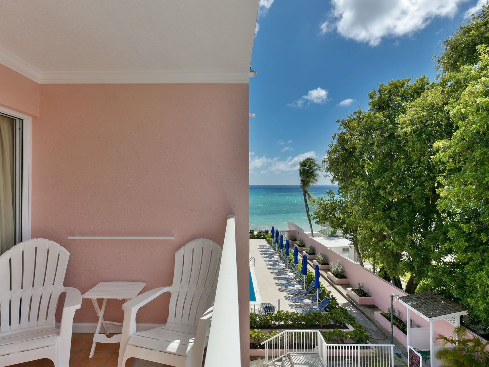 Superior Studio – Pool View balcony with white lounge chairs and a stunning view at Butterfly Beach Hotel