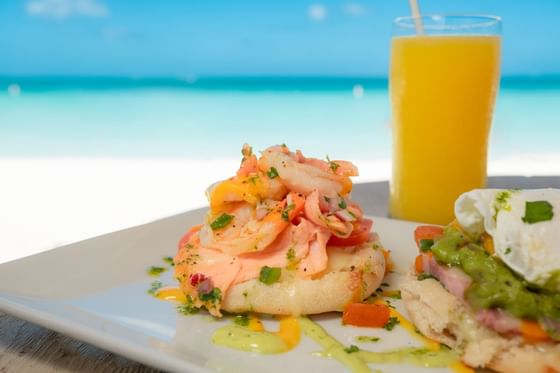 Smoked Salmon dish with fresh juice served on beachside dining table at Passions on the Beach