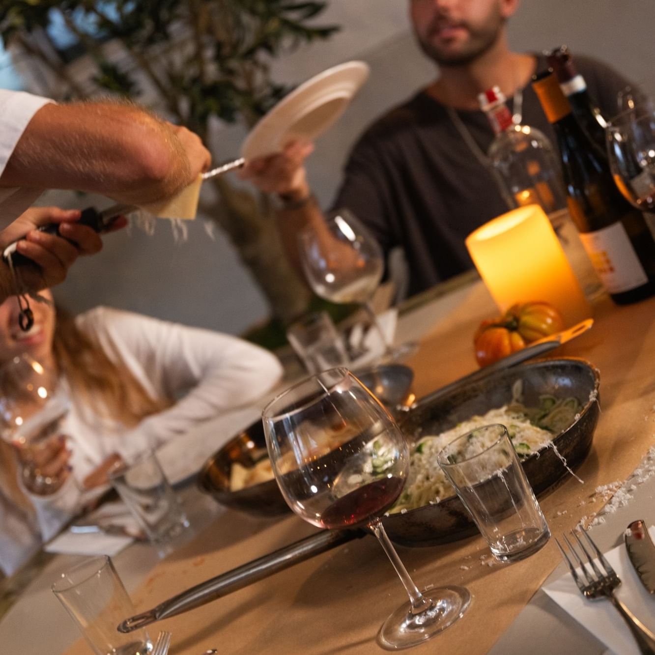 Guests enjoying a shared dining experience with wine and food at a table during Sundays at Bella
