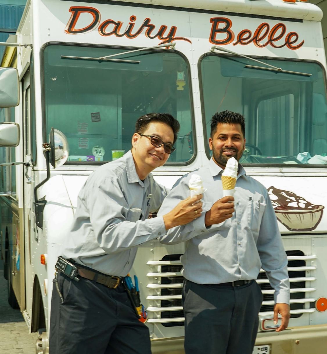 Deux personnes en uniforme mangeant une glace près d'un camion Dairy Belle à l'hôtel X Toronto
